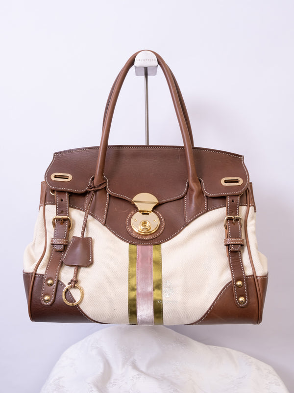 Canvas and brown leather tote firkin bag with gold hardware and striped center detail.