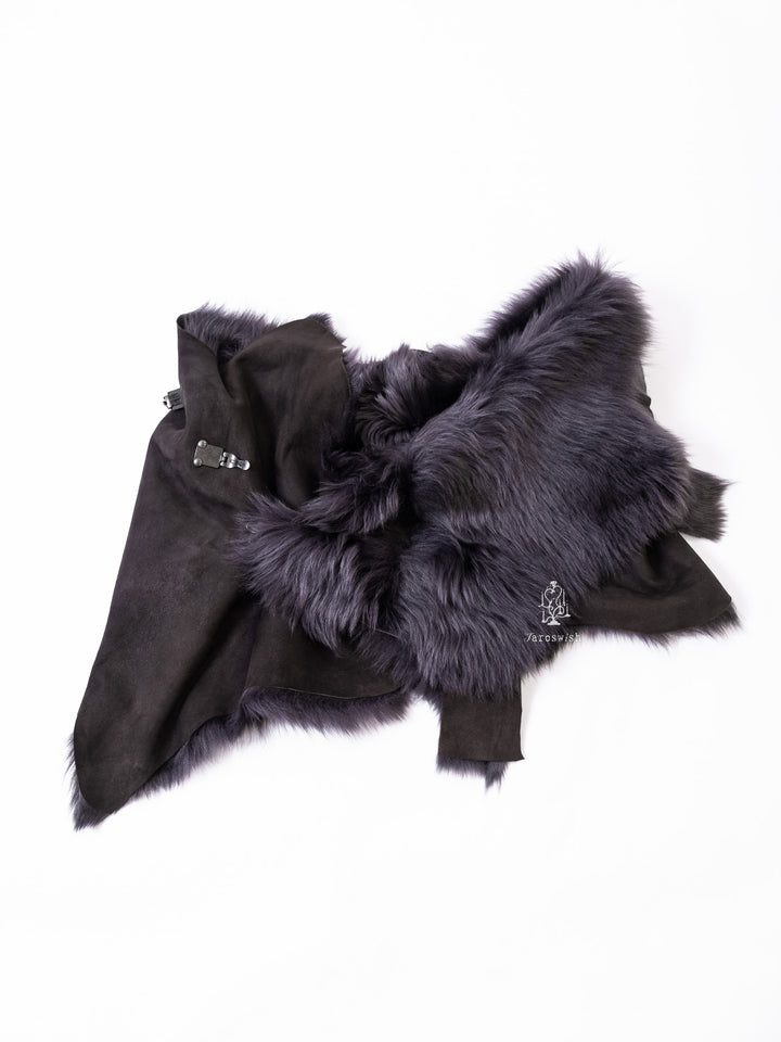Black asymmetric faux fur shawl with suede base and buckle closure.