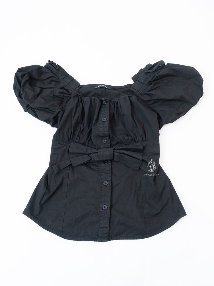 Black puff-sleeve blouse with front buttons and large bow detail.